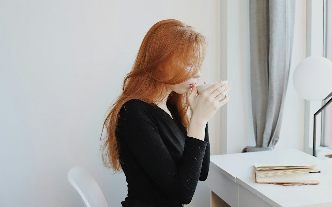 Przeciążona kobieta przy biurku w domowym wnętrzu, spokojna ilustracja wyczerpania i stresu; fotografia Good Faces / Unsplash